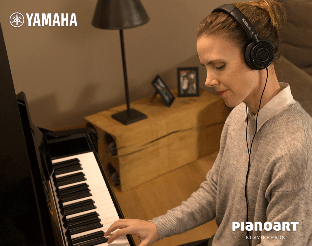 Frau spielt lächelnd auf einem Yamaha Silent Piano Zuhause