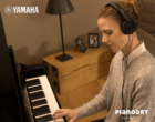 Frau spielt lächelnd auf einem Yamaha Silent Piano Zuhause