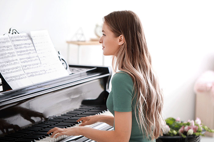 Frau spielt auf einem Flügel Klavier