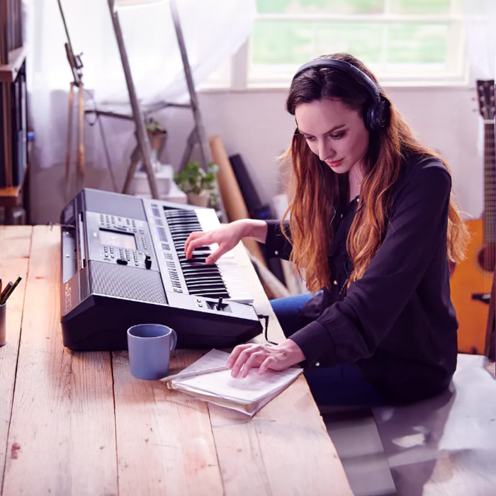 Eine Frau komponiert am Yamaha PSR SX-700 Keyboard