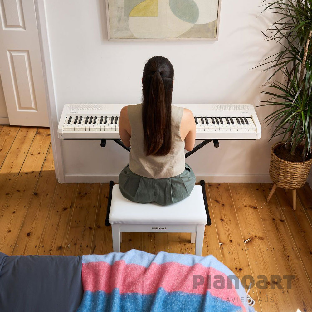 Frau lernt Klavierspielen mit Roland FP-40 WH in Weiß